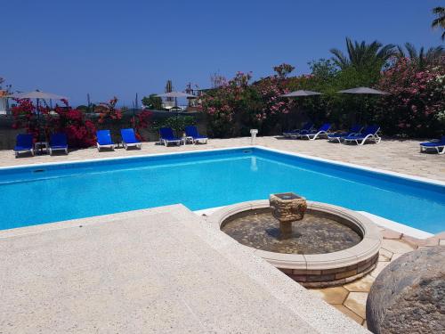 a swimming pool with a fountain in the middle at Paradise in Kérynia