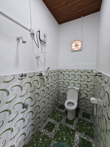 a bathroom with a toilet and a shower at Hotel Angel Inn Beach in Trincomalee