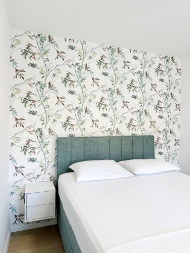 a bedroom with a bed and a wall with a floral wallpaper at Apartments Vinka in Jelsa