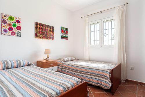 sypialnia z dwoma łóżkami i oknem w obiekcie Casa Huerto del Pitorreo w mieście Conil de la Frontera