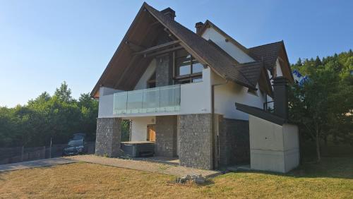 a house with a balcony on the side of it at Komforna planinska kuća za odmor in Mrkopalj