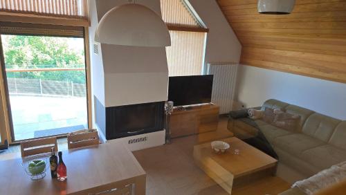 a living room with a couch and a table at Komforna planinska kuća za odmor in Mrkopalj