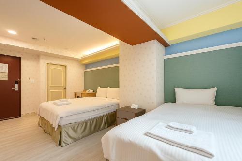 a room with two beds in a hotel room at Elizabeth Hotel in Taichung