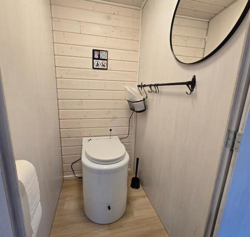 a small bathroom with a toilet and a mirror at Stuga med strandbastu in Oravais