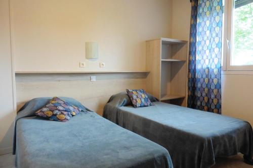 a room with two beds and a window at Gîtes plouraboué "Lou Chai" in Navailles-Angos