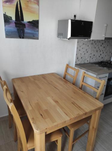 a wooden table and chairs in a kitchen at Apartment Topic in Baška Voda