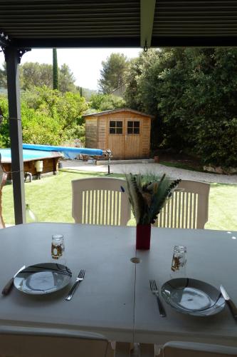 a white table with plates and silverware on it at Chambre d'hôte, SdB & accès privé, piscine, jardin in Gémenos