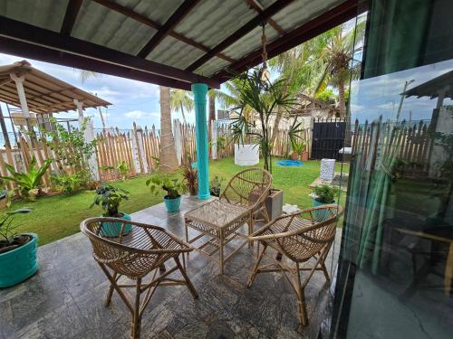 a patio with four chairs and a table and an umbrella at Hotel Angel Inn Beach in Trincomalee