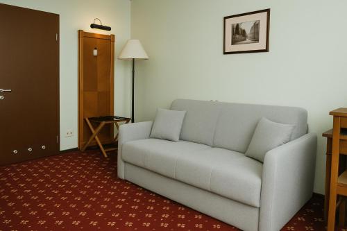 a living room with a couch in a room at Hotel Solaris in Toruń