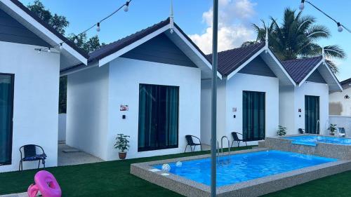 a house with a swimming pool in the yard at Dtamu Mama Roomstay w Pool and Wifi in Kertih