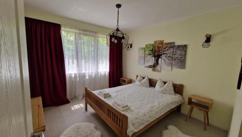 a bedroom with a bed and a window with red curtains at University Apt in Baia Mare