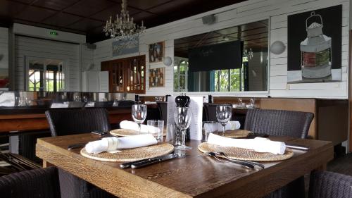 drewniany stół z serwetkami i okularami w restauracji w obiekcie La Maison du Bassin w mieście Cap-Ferret