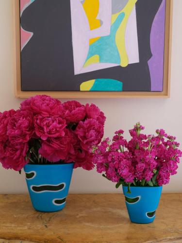 two blue vases filled with pink flowers on a table at Hotel Cipriani, A Belmond Hotel, Venice in Venice