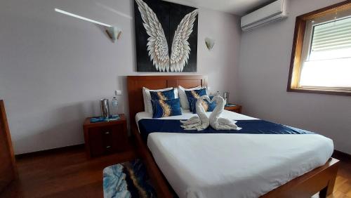 a bedroom with a bed with blue and white sheets at ALOJAMENTO SAUDADE in Gafanha da Boa Hora