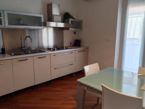 a kitchen with a table and a sink and a stove at Manin Private SPA, Luxury Apartment very close to the sea, with beach umbrella and deckchairs included in Pescara