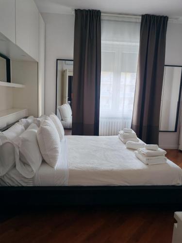 a bedroom with a large bed with white sheets and pillows at Manin Private SPA, Luxury Apartment very close to the sea, with beach umbrella and deckchairs included in Pescara
