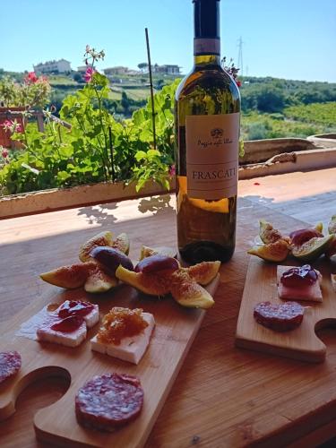 a bottle of wine next to a cutting board with food at Poggio agli Ulivi in Frascati