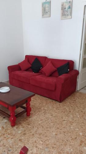 a red couch in a living room with a coffee table at Flat in Olbia Centro in Olbia