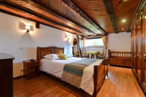 a bedroom with a large bed and a wooden ceiling at Gîte Oncle Yerry Ostheim in Ostheim