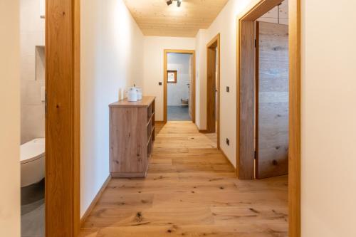 a hallway leading to a bathroom with a wooden floor at Madlhof in Himmelreich