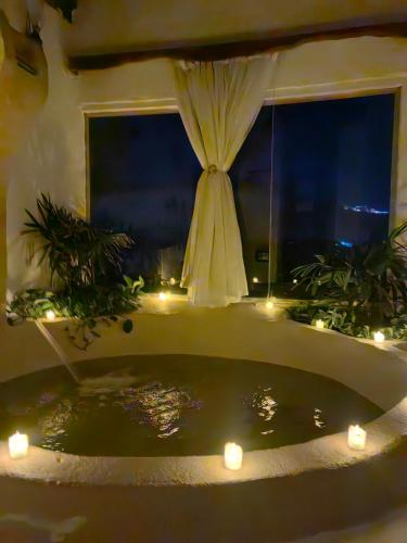 a room with a bath tub with candles and a window at Nala Narty Boutique Hotel & Farm in Aswan