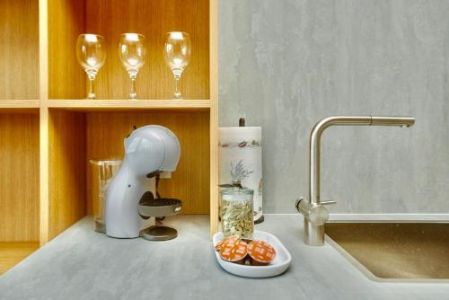 a kitchen counter with wine glasses and a bowl of food at Flat in Vlinius city center in Vilnius
