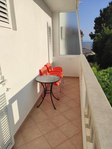 a patio with a table and chairs on a balcony at Apartment Topic in Baška Voda