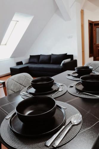 a table with black plates and utensils on it at TOTO's apartment in Gheorgheni