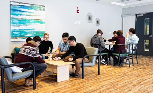 a group of people sitting at tables in a room at Hôtel Résidence de La Cité in Ottawa