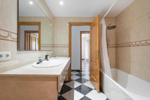 a bathroom with a sink and a tub and a mirror at Casa Campillos in Llucmajor