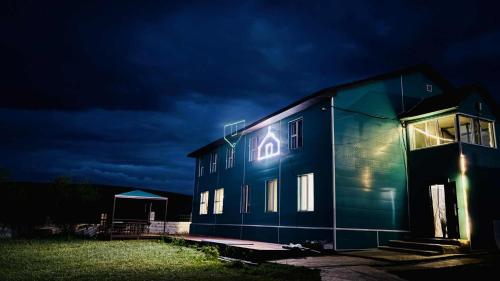 a building with a neon sign on it at night at Gaya's Guest House in Harhorin