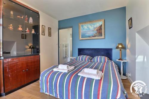 a bedroom with a large bed and a dresser at Les ormelles in Montreuil-sur-Ille
