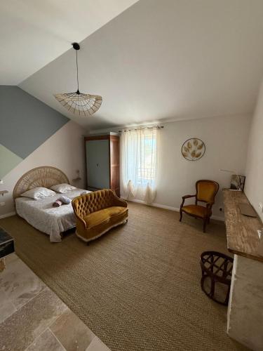 - une grande chambre avec un lit et une chaise dans l'établissement Maison de charme, à Lapalud