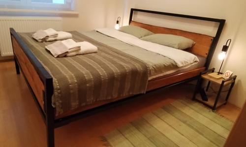 a bedroom with a large bed with towels on it at Apartman Erdoglija in Kragujevac