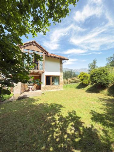 a view of a house with a yard at Explora Picos de Europa in Cosgaya