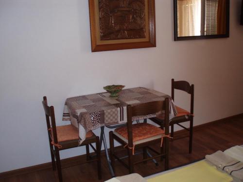 a dining room with a table and four chairs at M Group studio in Tivat