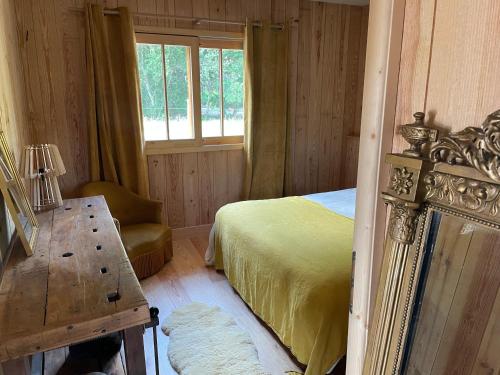 a bedroom with a bed and a chair and a window at Belle maison contemporaine en bois des Landes - Proche Contis Plage - Océan in Mézos