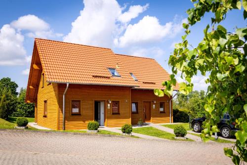 a small wooden house with an orange roof at Premiumferienhaus Vanua in Hasselfelde