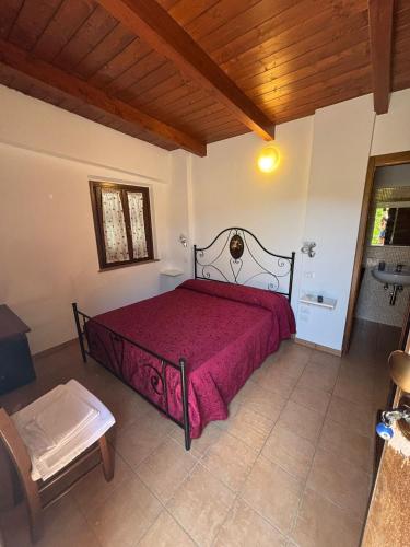 a bedroom with a bed with a red bedspread at B&B Da Fiorò in Massignano