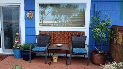 two chairs and a table in front of a house at Blū House in Williamsburg