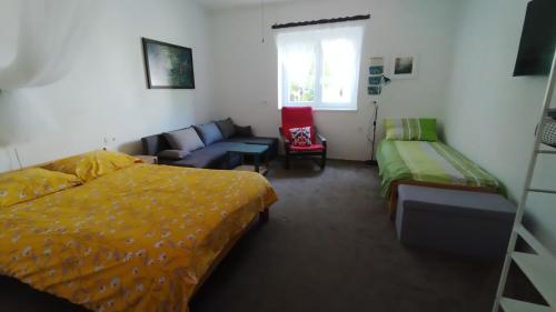 a bedroom with a bed and a couch at Hiša Tarka in Dobrovnik
