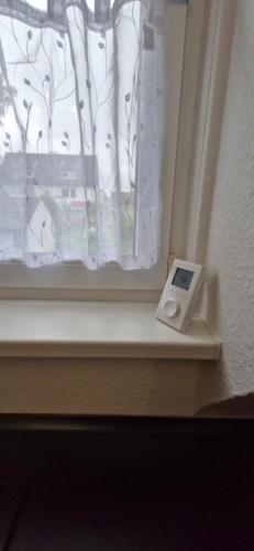 a window with a thermometer sitting on a window sill at Ferienwohnung Sonnenhof - Remscheid - Garten - Parken - Küche - Netflix - Nähe Vaillant und Sana-Klinikum in Remscheid