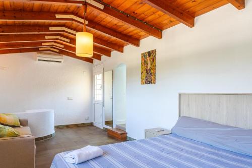 une chambre avec un lit et un plafond en bois dans l'établissement villa Jarana, à Lloret de Mar