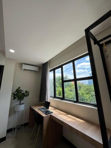 a room with a desk and a window with a laptop at Alzeto Coliving in Legian