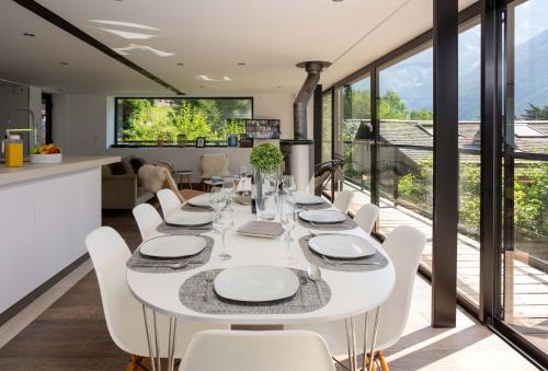 une salle à manger avec une table blanche et des chaises blanches dans l'établissement Chalet La Source - Chamonix All Year, à Chamonix-Mont-Blanc