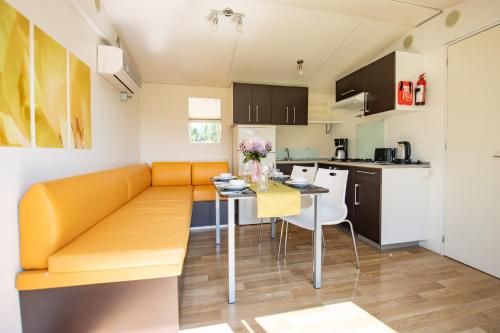 a living room and kitchen with a couch and a table at Ferien Hotel Spreewald in Kolkwitz