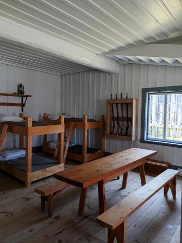 a room with a wooden table and benches at Fort Ingall in Notre-Dame-du-Lac