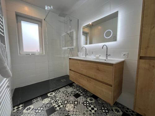 a bathroom with a sink and a mirror at La Cour de Mamama Appartement 6 in Ohnenheim