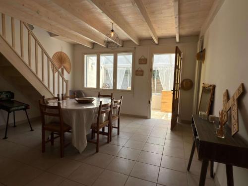 une salle à manger avec une table et des chaises dans l'établissement Valras-Loc Grande maison familiale, à Valras-Plage