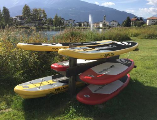 a pile of kayaks on a rack next to a body of water at Crap da Flem - 3.5 Zimmer Ferienwohnung am Sonnenhang von Flims in Flims
